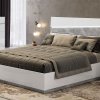 Λευκό κρεβάτι με μαρμάρινη λεπτομέρεια και φωτισμό