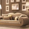 Αριστοκρατικός τριθέσιο καναπές ντυμένος με ύφασμα υψηλής ποιότητας. Είναι σχεδιασμένος σε χρυσές αποχρώσεις ενώ τα μπράτσα του είναι καμπυλωτά.