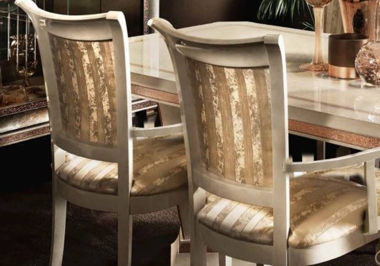 Καρέκλα σχεδιασμένη σε χρώμα ιβουάρ και διακοσμημένη με κάθετες μπεζ γυαλιστερές ρίγες.