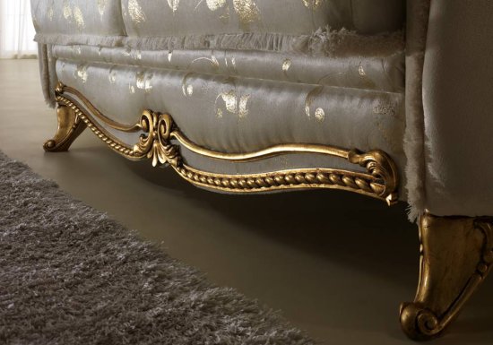 Καναπές διθέσιος ο οποίος είναι σχεδιασμένος σε χρώμα μπεζ και διακοσμημένος με χρυσή κορώνα και χρυσές λεπτομέρειες.