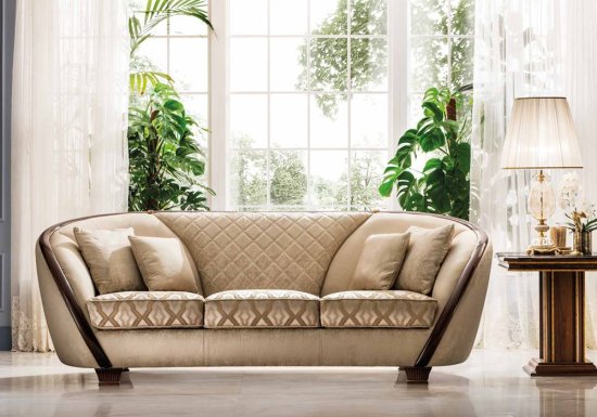 Τριθέσιος καναπές σχεδιασμένος σε χρώμα μπεζ. Είναι διακοσμημένος με καρυδί στοιχεία.