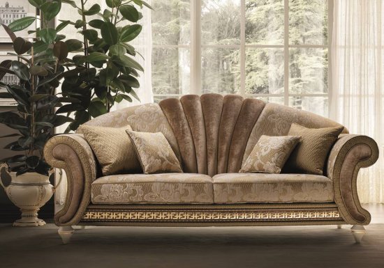 Τριθέσιος καναπές ο οποίος είναι σχεδιασμένος σε χρώμα καφέ χρυσό και διακοσμημένος με βελούδινα στοιχεία και μπεζ λουλούδια.