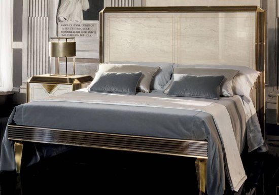 Κρεβάτι σχεδιασμένο σε χρώμα εκρού και διακοσμημένο με ψηλό κεφαλάρι και καμπυλωτά τριγωνικά πόδια.
