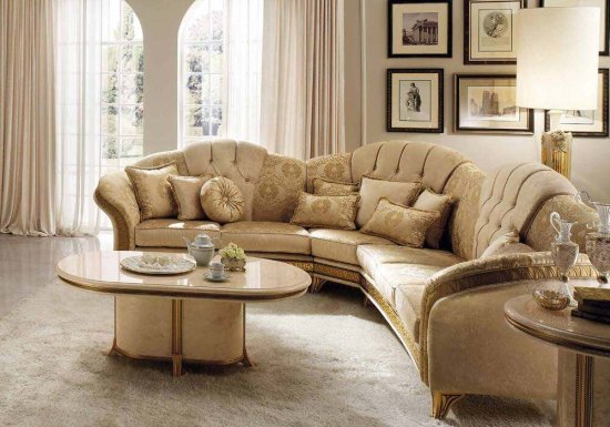 Γωνιακός καναπές σχεδιασμένος σε χρώμα μπεζ με χρυσά πόδια.