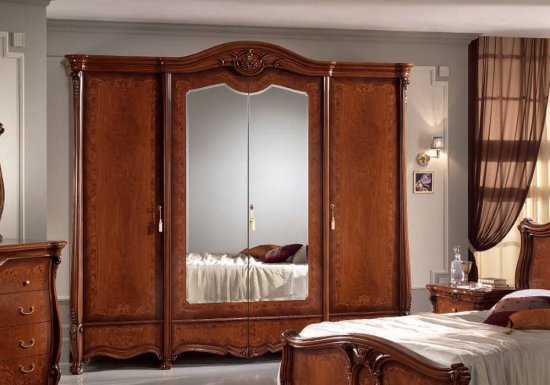 Κλασσική ντουλάπα τετράφυλλη σχεδιασμένη σε χρώμα καρυδί και διακοσμημένη με ολόσωμο καθρέφτη.