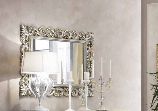 Επιβλητικός καθρέφτης σχεδιασμένος σε χρώμα ασημί και διακοσμημένος με χρυσές λεπτομέρειες.