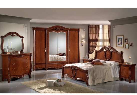 Κλασσικό κρεβάτι σε χρώμα καρυδί το οποίο διαθέτει ιδιαίτερες καμπυλωτές λεπτομέρειες.