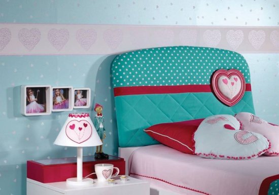 Κρεβάτι ιδανικό για παιδικό δωμάτιο το οποίο διαθέτει υφασμάτινο κεφαλάρι σε χρώμα τιρκουάζ το οποίο είναι διακοσμημένο με κόκκινες λεπτομέρειες.