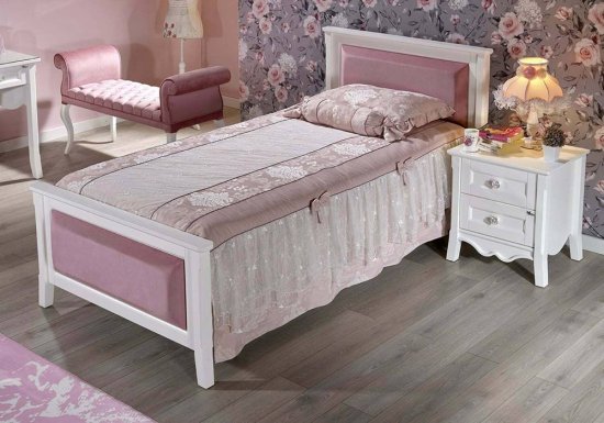Κρεβάτι σε χρώμα λευκό το οποίο είναι διακοσμημένο με ροζ κεφαλάρι και ροζ ποδαρικό.