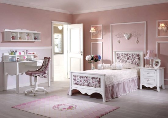 Κρεβάτι παιδικού δωματίου σε χρώμα λευκό με αποθηκευτικό χώρο και ροζ λουλουδάκια στο κεφαλάρι και στο ποδαρικό του.
