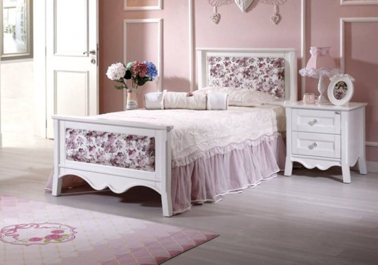 Ρομαντικό κρεβάτι ιδανικό για παιδικό δωμάτιο σε χρώμα λευκό του οποίου το κεφαλάρι του και το ποδαρικό του είναι διακοσμημένα με ροζ λουλουδάκια.